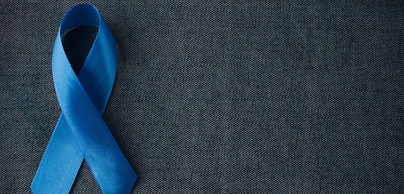 Ruban de tissu bleu signifiant le cancer de la prostate sur fond gris foncé