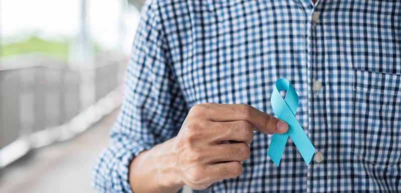 Homme qui a dans la main le petit bandeau bleau représentant le cancer de la prostate